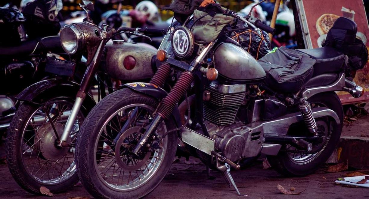 Deux motos classiques à phare rond garées côte à côte dans la rue