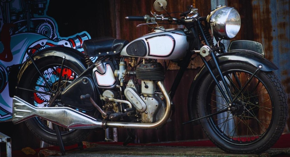 Moto de collection d'avant-guerre au réservoir argenté et échappement queue de poisson