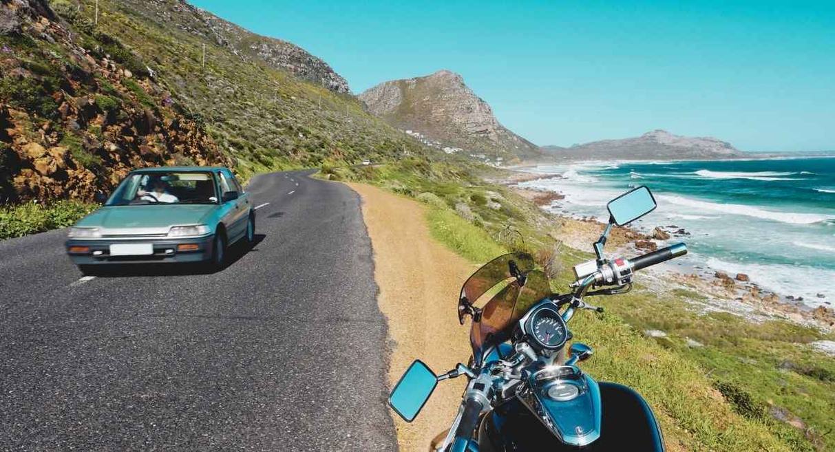 Moto routière arrêtée au bord d'une route côtière de montagne