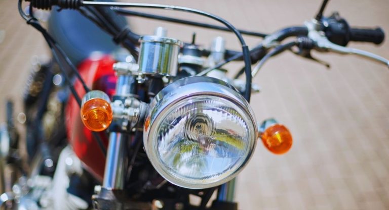Phare rond chromé et clignotants orange à l'avant d'une moto classique