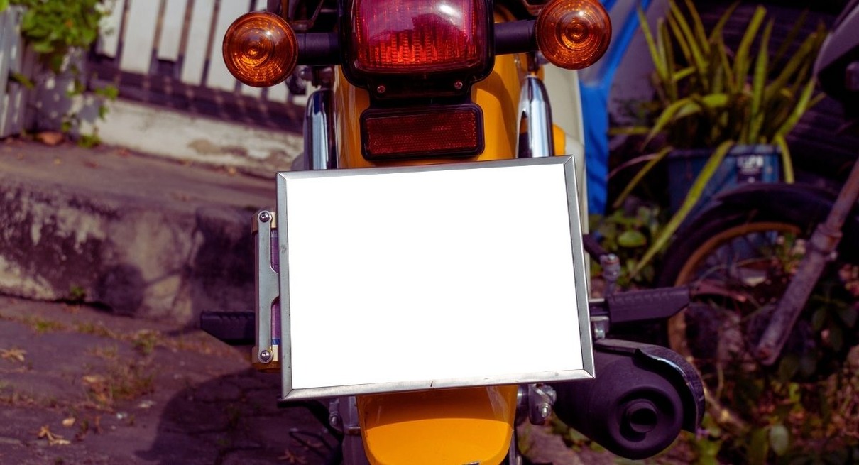 Arrière d'une moto jaune avec feu stop et plaque d'immatriculation vierge