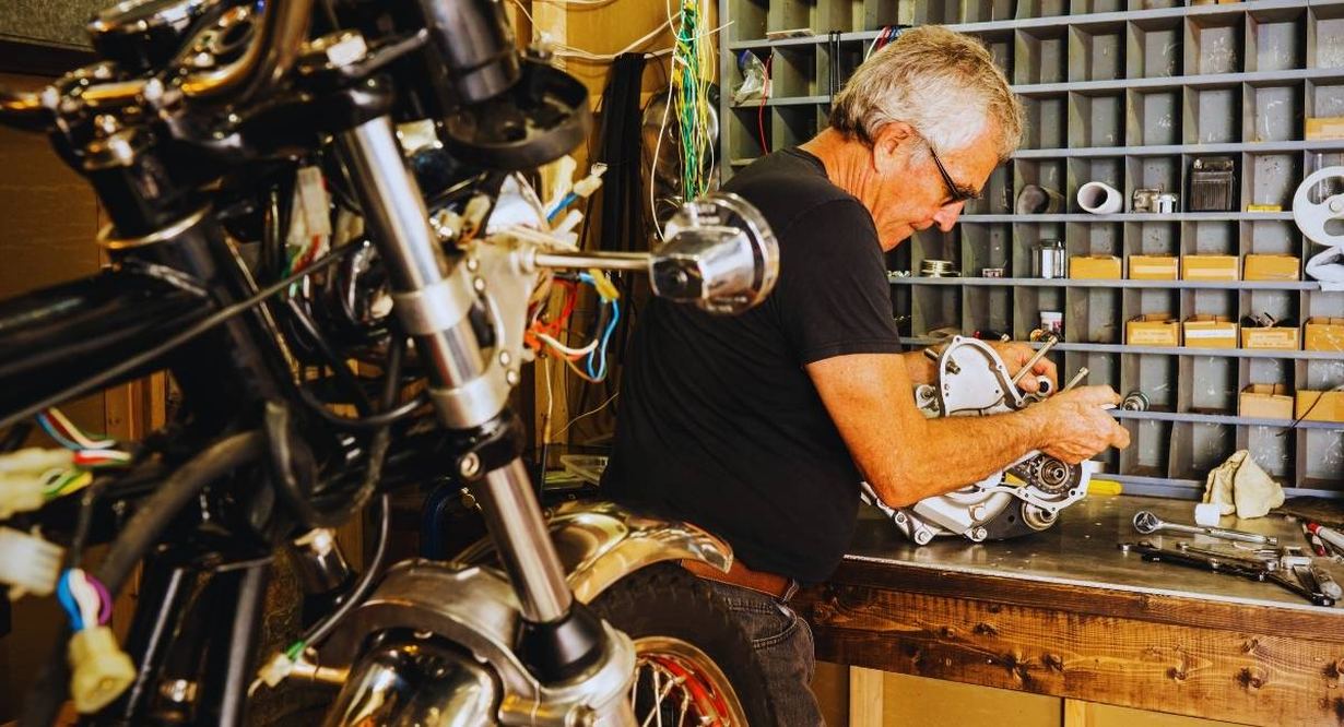 Mécanicien restaurant un carter moteur de moto ancienne sur son établi